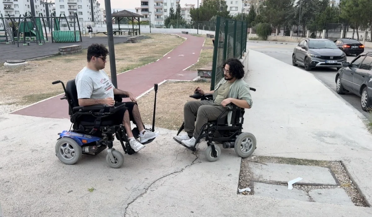 Osmaniye Kadirli'de Furkan Ulusoy, engelliler için arkadaşıyla akülü sandalyede gezdi
