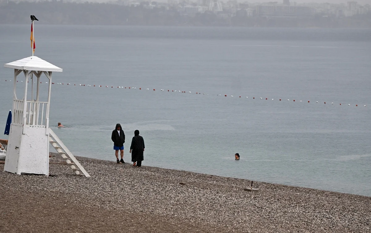 Antalya'da yağış altında Konyaaltı Sahili'nde vatandaşlar denize girdi